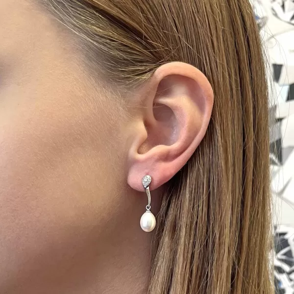 Strieborné náušnice visiace s oválnou riečnou perlou a zirkónmi bielej 21097.1B